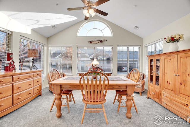 carpeted dining area featuring ceiling fan, lofted ceiling, and a healthy amount of sunlight