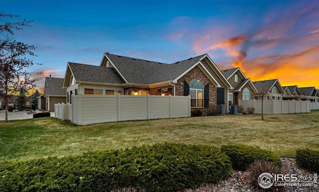 property exterior at dusk with a lawn