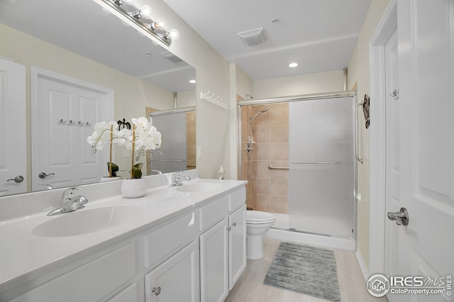 bathroom featuring vanity, an enclosed shower, and toilet