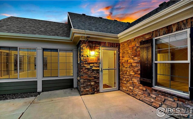 exterior entry at dusk featuring a patio area