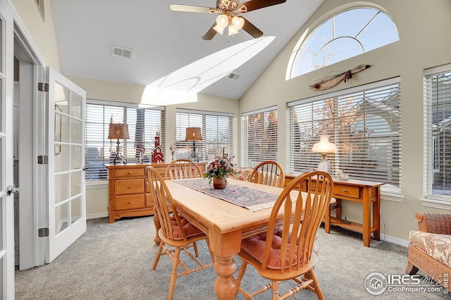 carpeted dining room featuring ceiling fan and vaulted ceiling