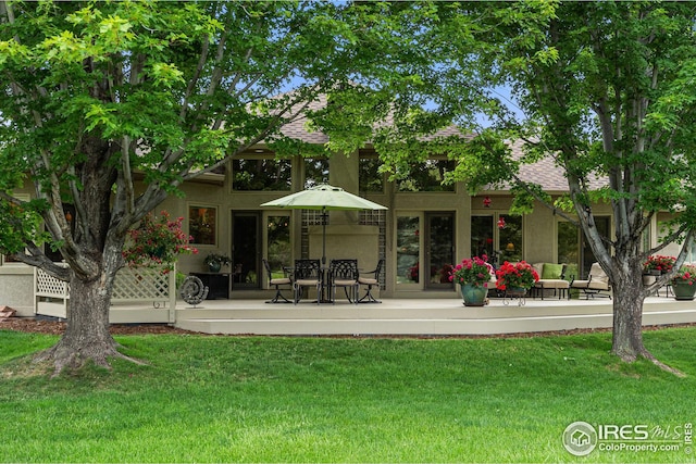 rear view of property featuring a lawn