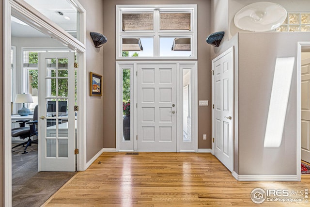 entrance foyer featuring french doors, a high ceiling, and light wood-type flooring