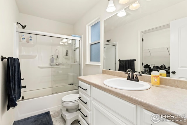 full bathroom with shower / bath combination with glass door, vanity, and toilet