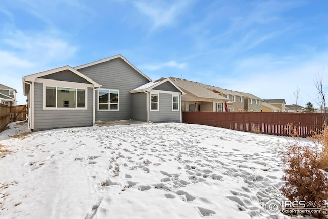 view of snow covered rear of property