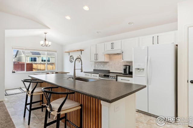 kitchen featuring vaulted ceiling, white cabinetry, sink, white fridge with ice dispenser, and a kitchen island with sink