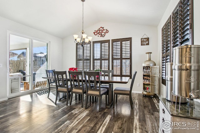 dining space with dark hardwood / wood-style flooring, lofted ceiling, and an inviting chandelier