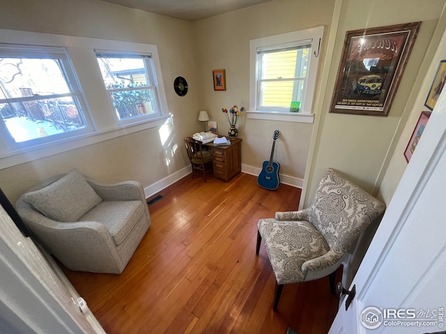 sitting room featuring wood-type flooring and a healthy amount of sunlight