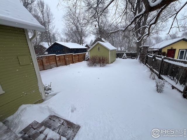 yard covered in snow featuring a storage unit