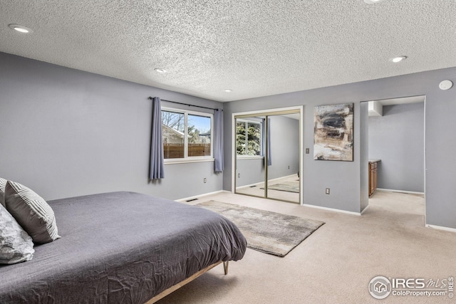 bedroom featuring light carpet, a closet, and a textured ceiling