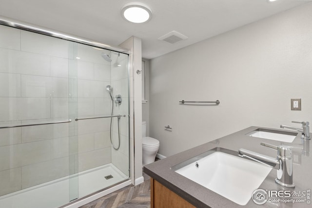 bathroom with walk in shower, parquet flooring, vanity, and toilet