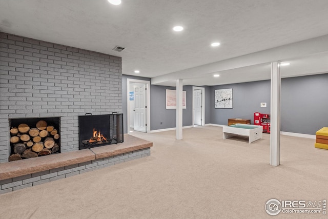 interior space with light carpet, a brick fireplace, and a textured ceiling