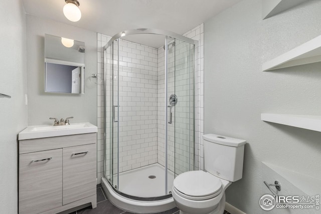 bathroom with vanity, a shower with shower door, and toilet