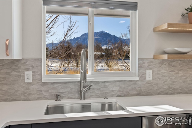 kitchen featuring dishwasher, a mountain view, sink, and backsplash