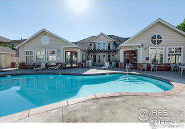 view of swimming pool with an outdoor structure and a patio area