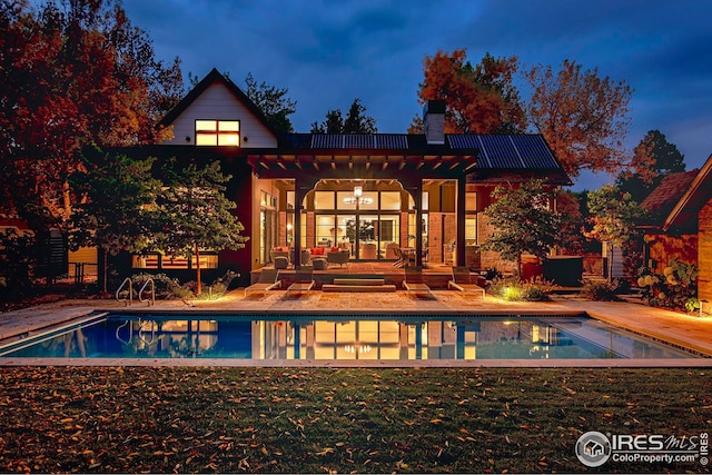 3621 21st St, Boulder, CO 80304 - back of house with roof mounted solar panels, a chimney, a patio, and an outdoor pool