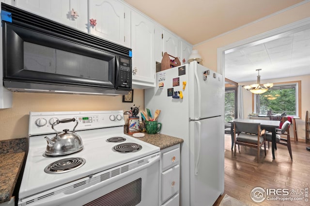 kitchen featuring white appliances, white cabinetry, hanging light fixtures, dark stone countertops, and wood-type flooring