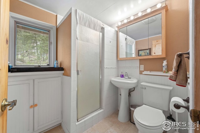 bathroom featuring tile patterned flooring, toilet, and a shower with shower door