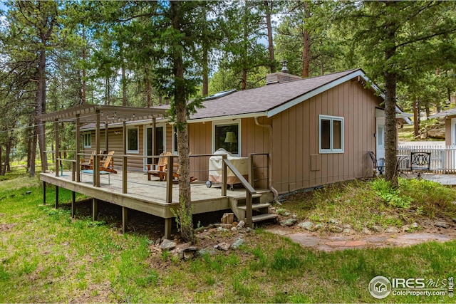 rear view of house featuring a deck and a pergola