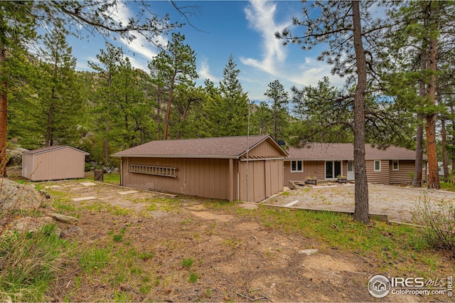 rear view of property with a storage shed