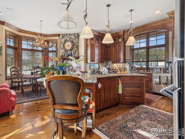 kitchen featuring hanging light fixtures, sink, dark wood-type flooring, and kitchen peninsula