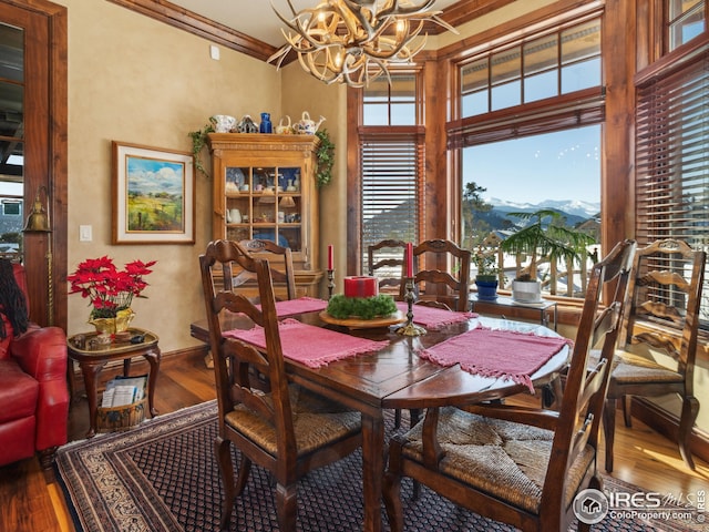 dining space featuring crown molding, a mountain view, hardwood / wood-style floors, and a notable chandelier