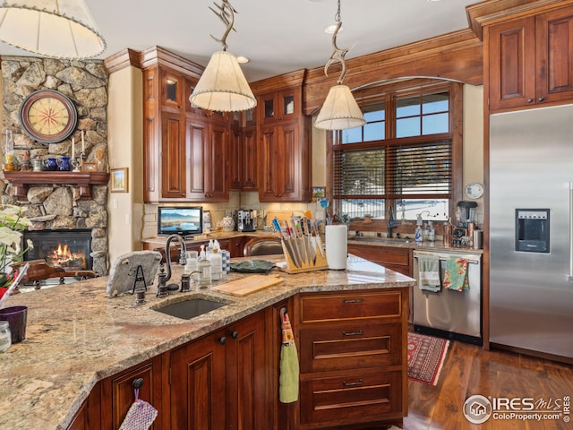 kitchen featuring sink, light stone countertops, dark hardwood / wood-style floors, and appliances with stainless steel finishes