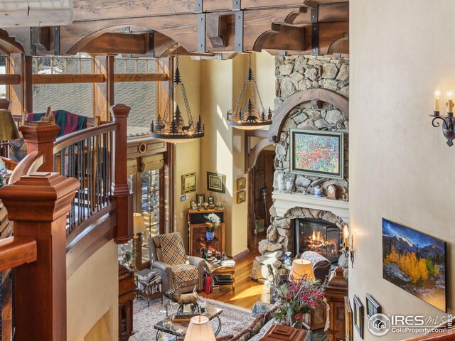 living area with a towering ceiling, hardwood / wood-style floors, and a fireplace