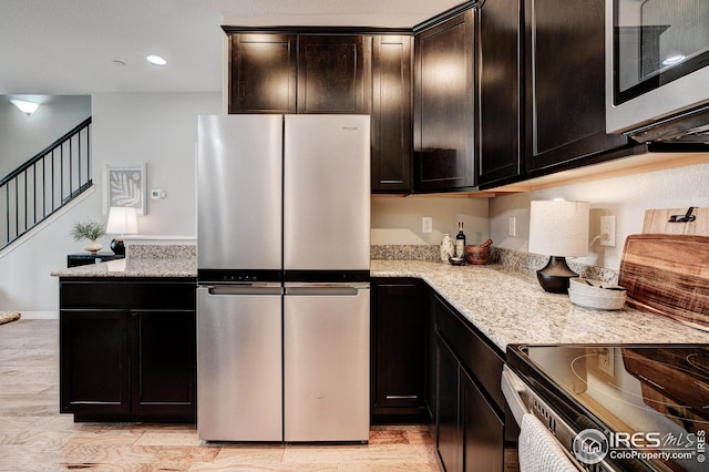 kitchen featuring stainless steel appliances, light stone countertops, and light hardwood / wood-style flooring