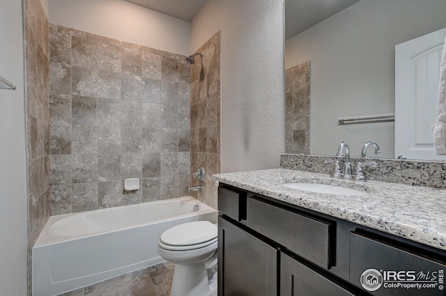 full bathroom with tiled shower / bath, vanity, and toilet