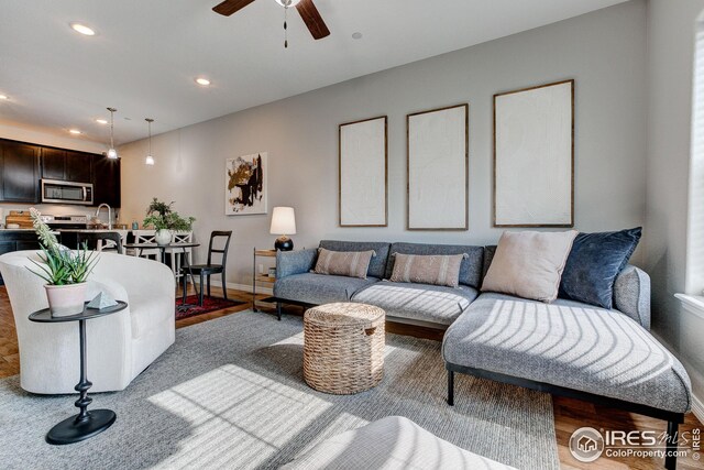 living room with sink, wood-type flooring, and ceiling fan