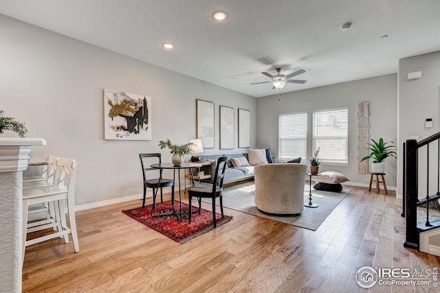 living room with light hardwood / wood-style flooring and ceiling fan