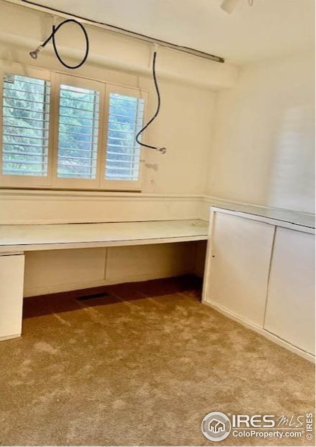 interior space featuring built in study area and carpet floors