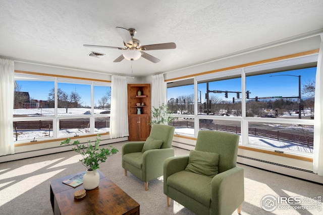 interior space with ceiling fan, visible vents, and baseboard heating