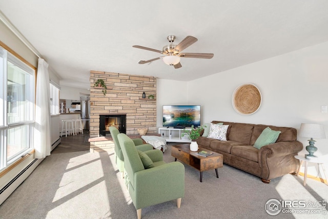 carpeted living area with a baseboard heating unit, a fireplace, and ceiling fan