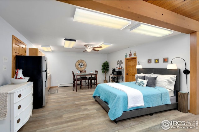 bedroom with light wood-style floors, a baseboard radiator, ceiling fan, and freestanding refrigerator