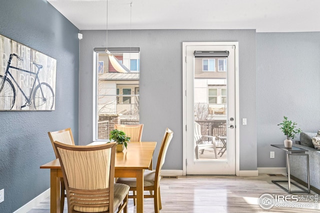 dining space featuring plenty of natural light and light hardwood / wood-style floors