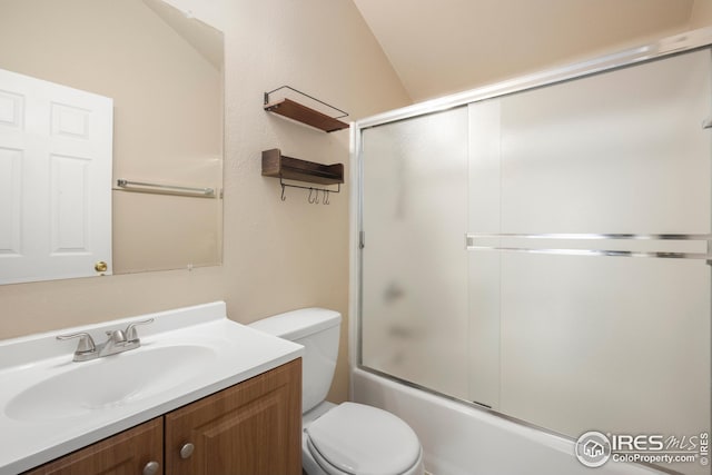 full bathroom with enclosed tub / shower combo, vanity, and toilet