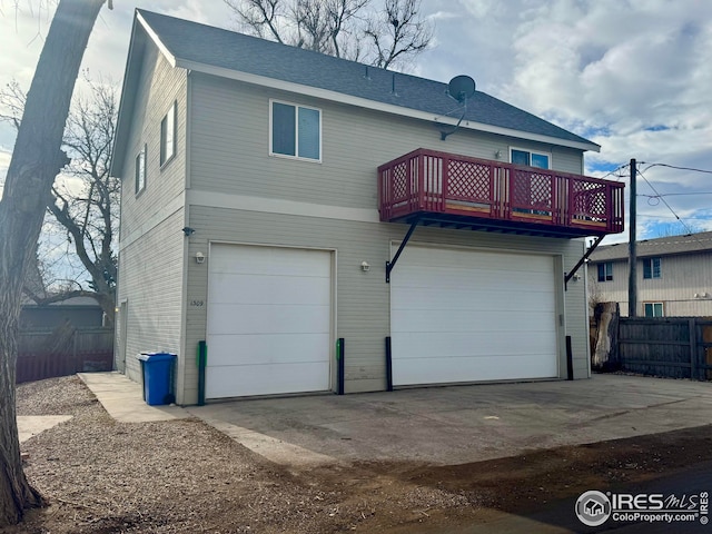 rear view of house with a garage and a balcony