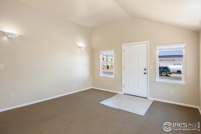 carpeted foyer entrance featuring lofted ceiling