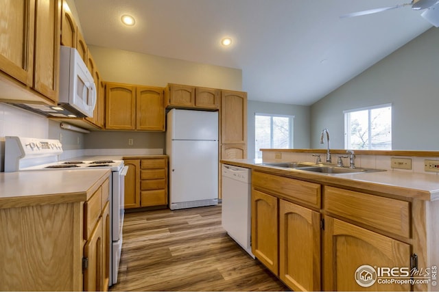 kitchen with white appliances, lofted ceiling, sink, and light wood-type flooring