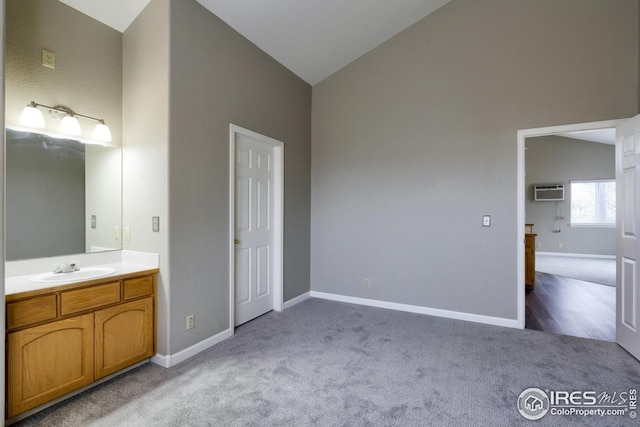 bathroom featuring vanity, a wall mounted AC, and high vaulted ceiling