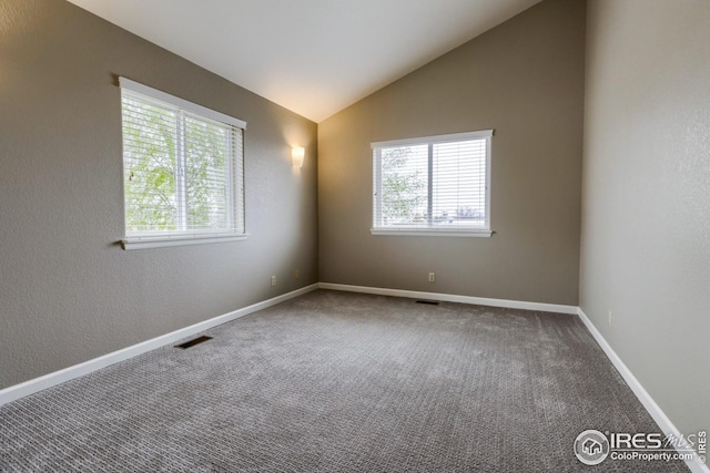 unfurnished room featuring lofted ceiling and carpet flooring