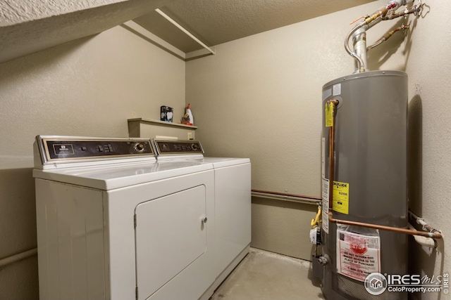 clothes washing area with gas water heater and washing machine and dryer