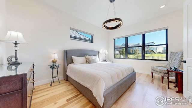 bedroom with baseboards, recessed lighting, and light wood-style floors