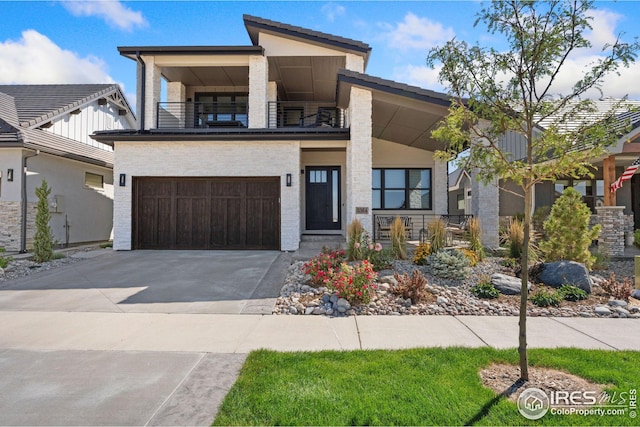 contemporary home featuring a garage, driveway, and a balcony