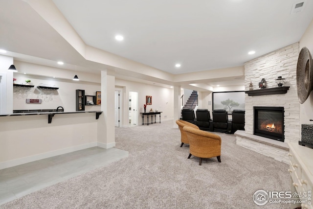 living area with a stone fireplace, recessed lighting, visible vents, baseboards, and stairs