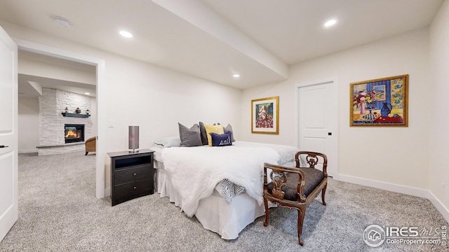 carpeted bedroom with a large fireplace, baseboards, and recessed lighting