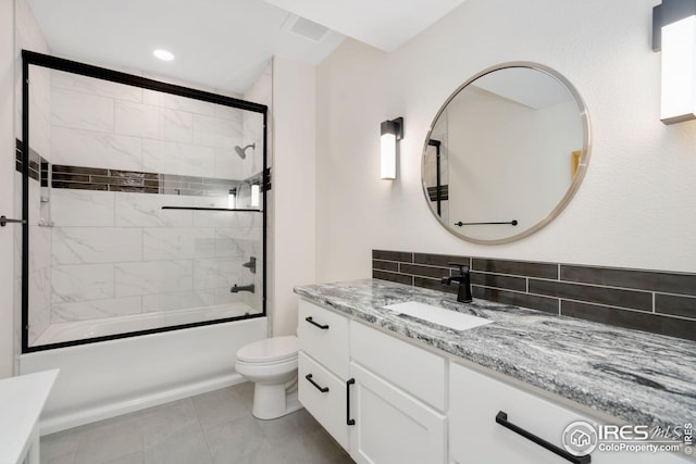 bathroom with enclosed tub / shower combo, toilet, tile patterned flooring, and vanity