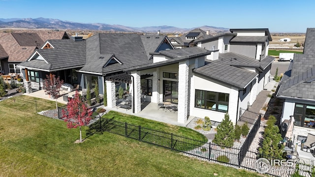 rear view of house with a yard, a patio, a mountain view, a residential view, and a fenced backyard